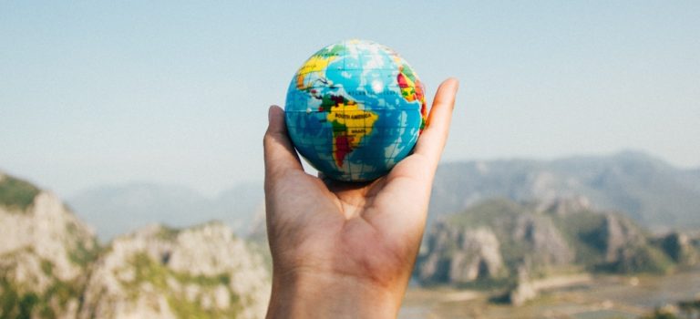 Photo of a hand holding a small globe to depict CFdating.com's new international matches feature enhancement for childfree dating singles.