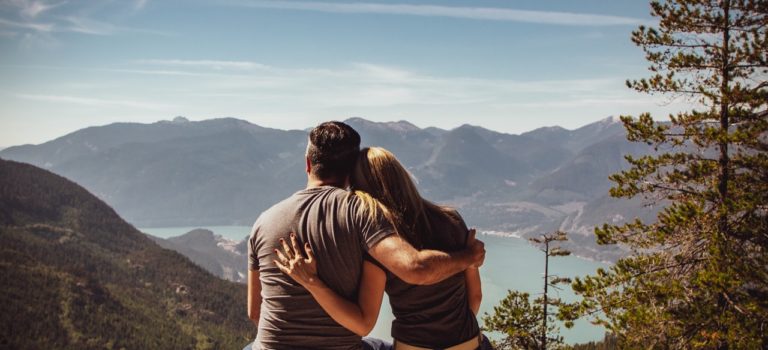 Childfree couple looking out over beautiful lake.